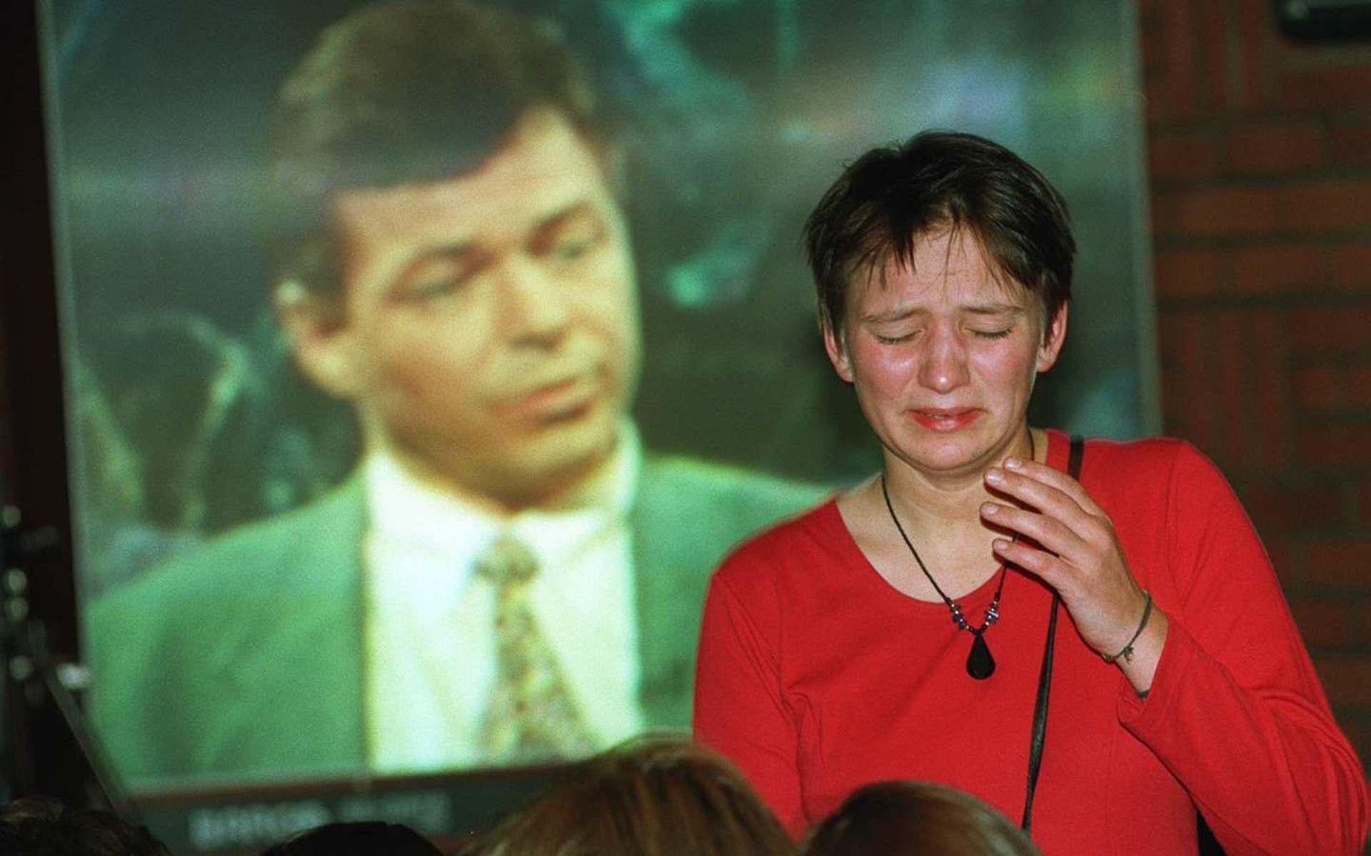 Tapet var ikke like lett å bære for alle som var tilstede ved Europabevegelsens valgvake etter folkeavstemningen om EU. En gråtende EU-tilhenger med Kjell Magne Bondevik på storskjerm i bakgrunnen. **** A crying EU supporter realising that her side has lost in the struggle for Norwegian membership in the EU. A telecasted image of Kjell Magne Bondevik, one of the leading anti EU spokesmen, in background.